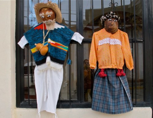 Male and female effigies hanging from window grate.