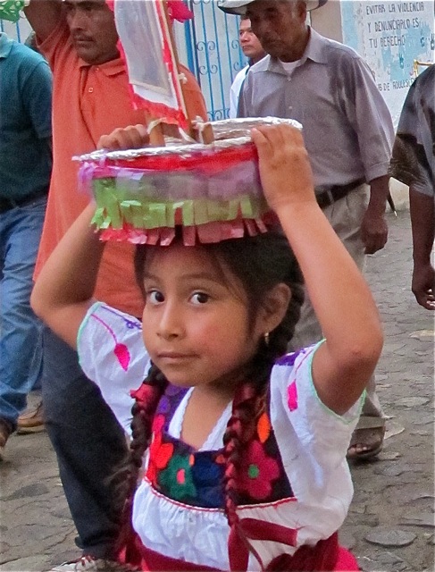 Young Zapotec girl carrying canasta on her head