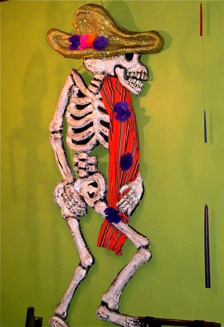 Skeleton with sombrero hanging on wall.