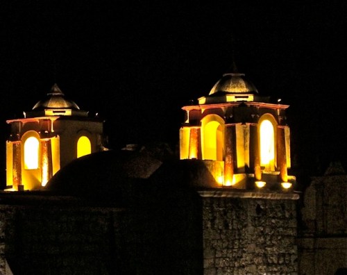 Lighted cupolas of Iglesia de San José against black night sky.