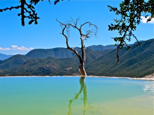 Pool dropping off over the cliff, with scenic background of mountains.