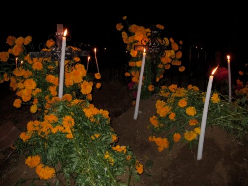 Marigolds and tall candles grave