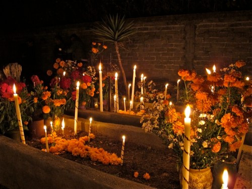 Tall candles and flowers in cemetary