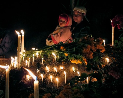 Mother holding child, illuminated by candles