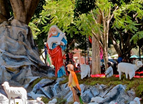 Long white-haired mannequin carrying lamb.
