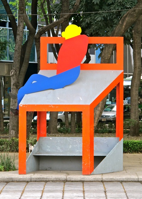 IMG_2060 Aluminum bench topped with a whimsical red chair with lounging figure.