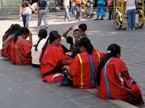 Triqui women sitting on a sidewalk