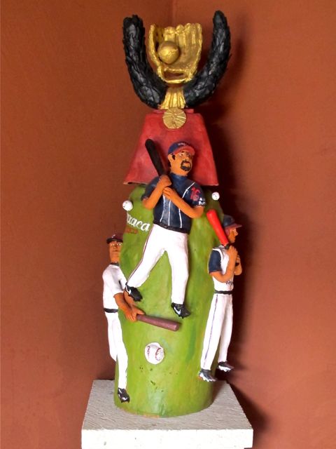 Sculpture of three baseball players topped by a gold mitt