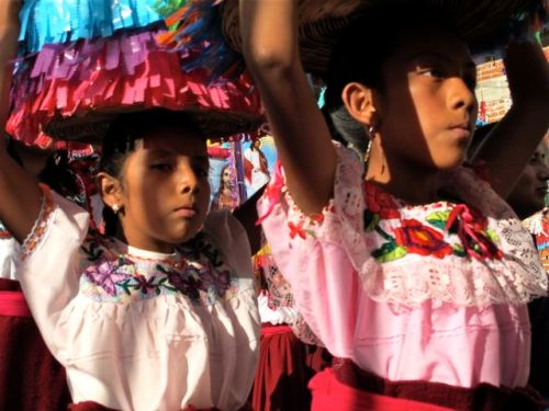Close-up of 2 young women carrying canastas on their heads
