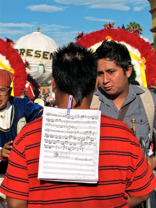 "Cuadrilla no. 2" sheet music clipped on the back of a man wearing a red and black striped shirt