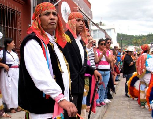 Two guys wearing red bandanas  on their head in foreground and crowd in background