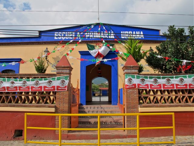 IMG_0737 Blue and peach colored school decorated with Mexican flag banners and drapes