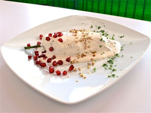 Serving of Chiles en Nogada on a white plate.