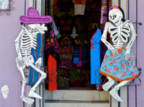 Male calavera and female calavera facing each other in a doorway