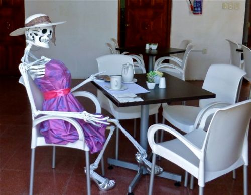 Catrina in lavender dress sitting at table