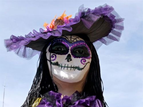 Close-up of face of a Catrina with lavender hat