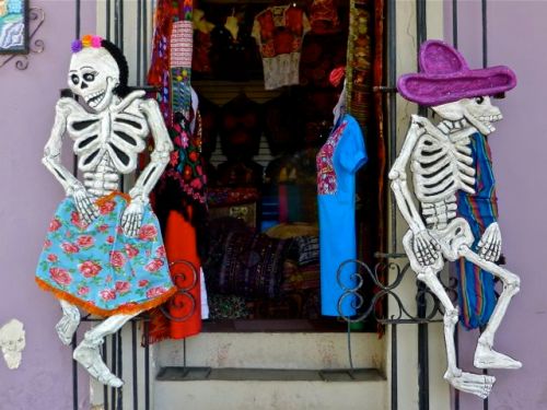 Male calavera and female calavera facing away from each other in a doorway