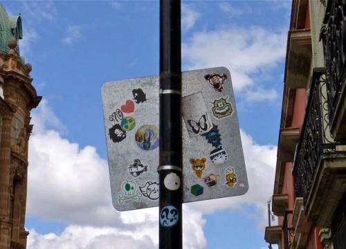 Stickers on the back of sign on lamp post