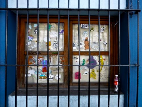 Stickers on window panes behind iron grating