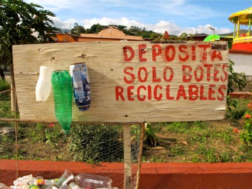 Sign "deposita solo botes reciclables with 3 plastic bottles nailed to it