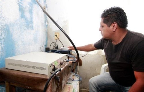 A local resident operates the equipment enabling mobile communications in Talea de Castro, Oaxaca State, Mexico, on August 17, 2013. 