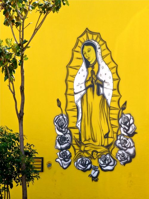Virgin of Guadalupe painted on yellow wall