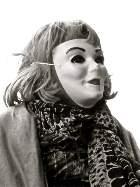 Man wearing female mask, wig, and clothing