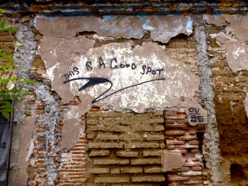 Crumbling adoble & brick wall with graffiti, "This is a good spot"