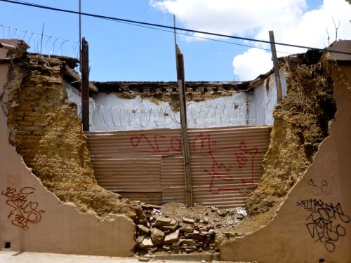 Crumbling adobe wall with graffiti creature by SCOM