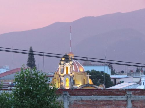 Pink tinged mountains & sky with church in foreground