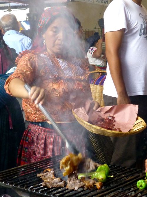 Woman at grill behind smoke
