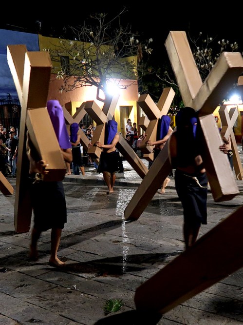 Purple hooded penitents carrying crosses