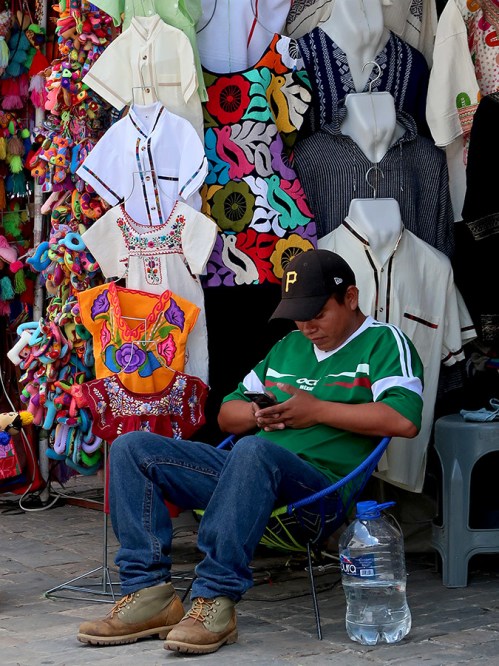 Young man in Mexico soccer jersey sitting